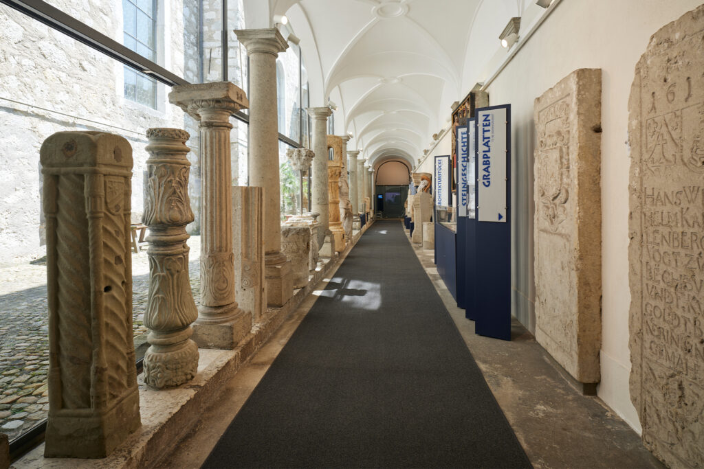 Blick in das Steinmuseum mit Steinobjekten, die links und rechts entlang des ehemaligen Kreuzganges des Jesutienkriche aufgereiht sind. Foto: David Aebi